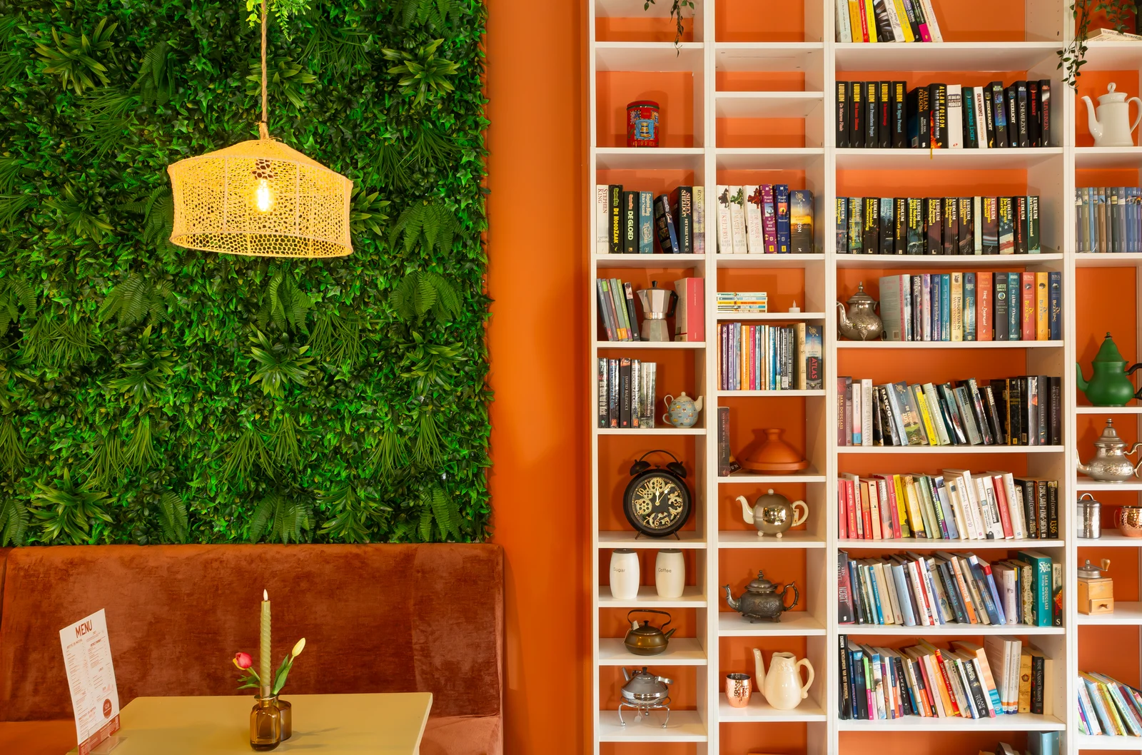 Een tafel bij de groene wand en de boekenkast van Bakkie & Baksel.