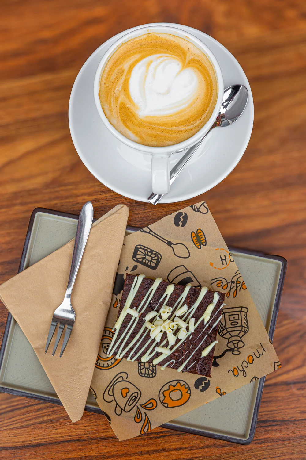 Cappuccino met een hartje in het melkschuim en een brownie.