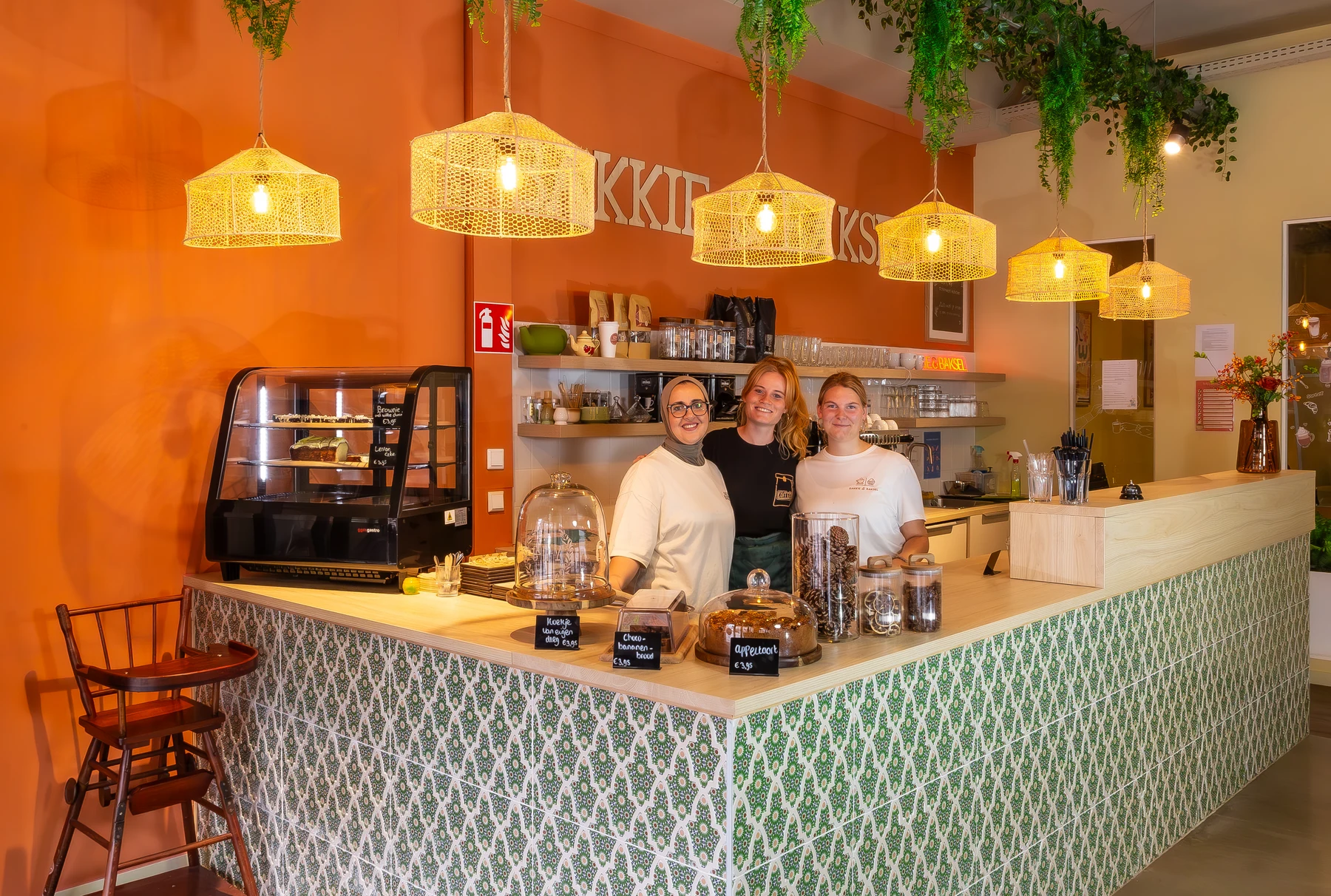 Drie collega's achter de bar van Bakkie & Baksel, tussen de koffie en huisgemaakte baksels.